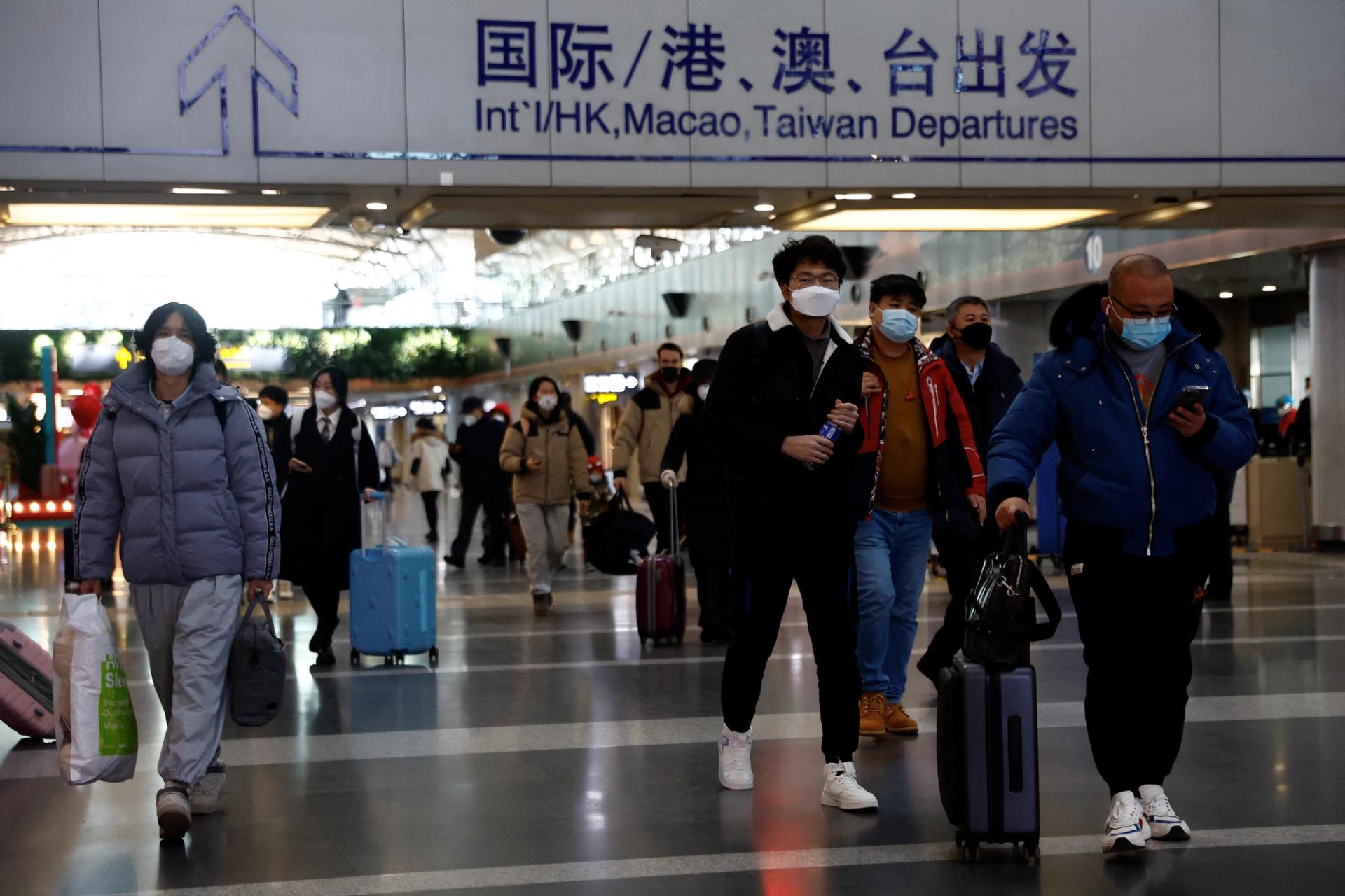 Travellers walk with their luggage at Beijing Capital International Airport, amid the coronavirus disease (COVID-19) outbreak in Beijing, China December 27, 2022