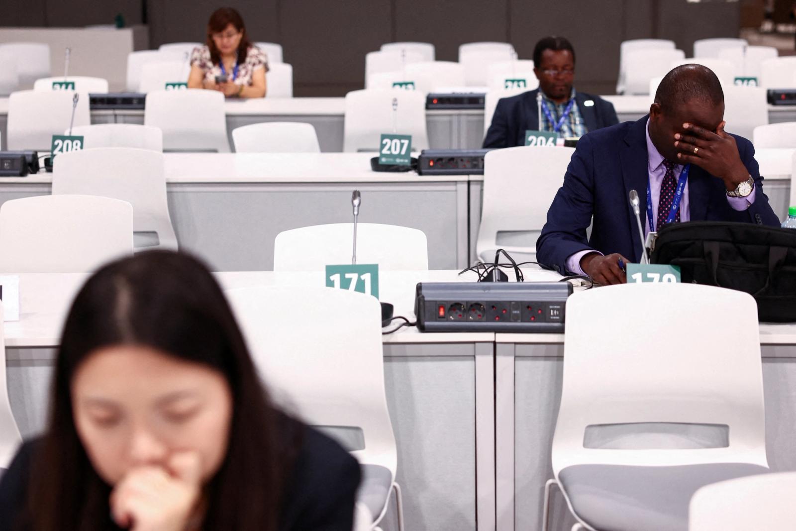 A delegate gestures as he works in between meetings during the final stages of the United Nations Climate Change Conference COP28.