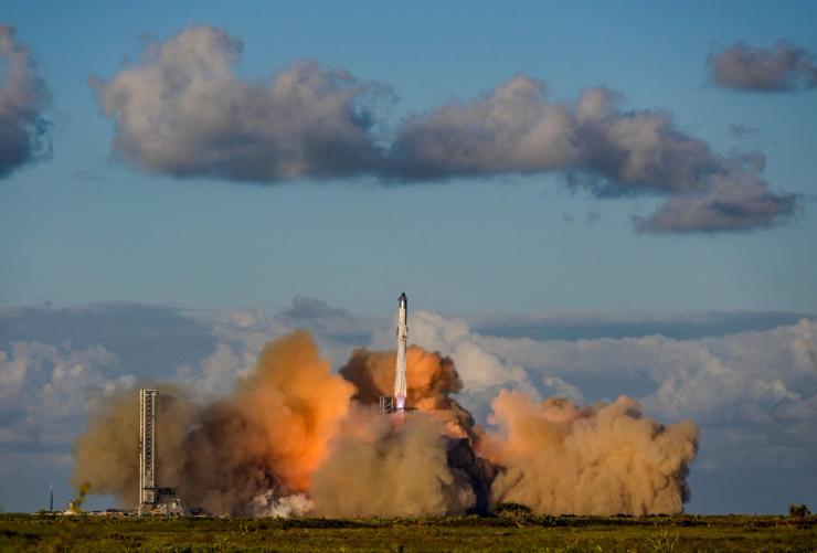A SpaceX Super Heavy booster carrying the Starship spacecraft lifts off.