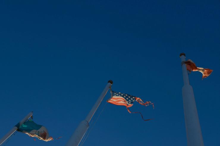 The flags of Mexico, the United States and Canada fly in a park.