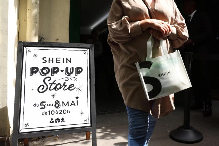 A woman leaves a pop-up store of Chinese fast-fashion retailer Shein in Paris, France