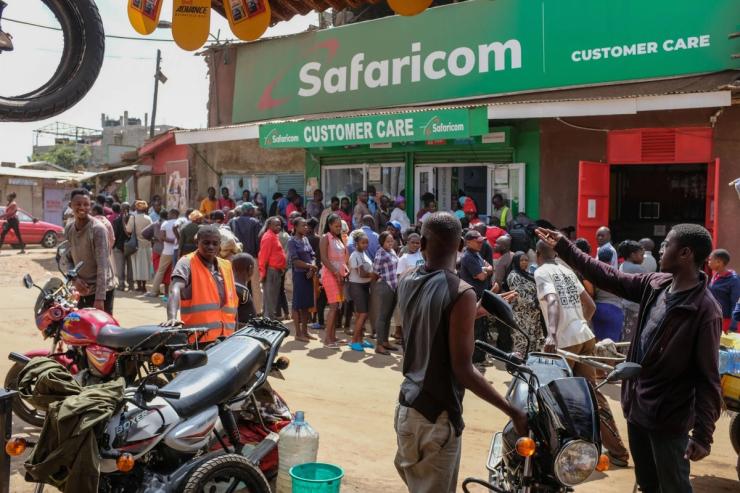Locals queue up outside a Safaricom customer care shop.