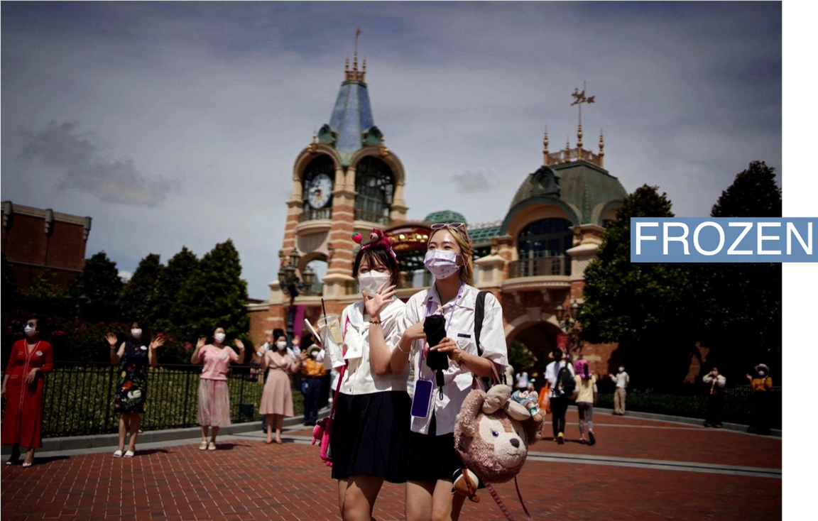 People wearing face masks visit the Shanghai Disney Resort