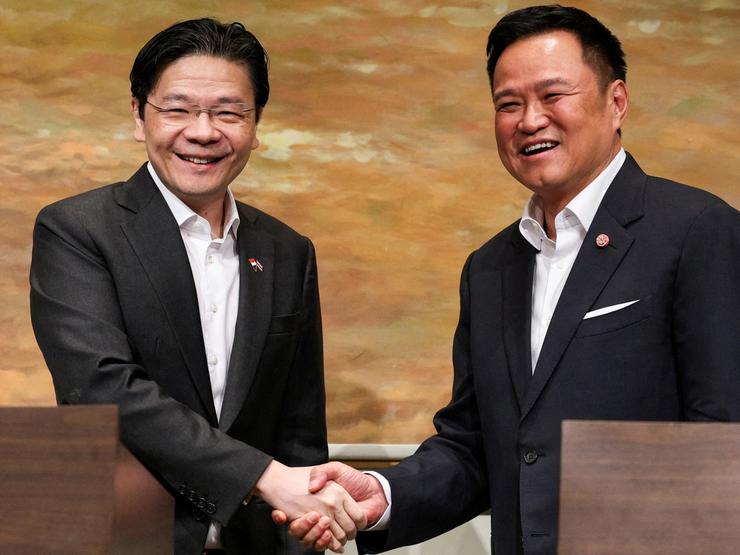 Thailand’s PM Anutin Charnvirakul and Singapore’s PM Lawrence Wong shake hands during a press conference in Bangkok.