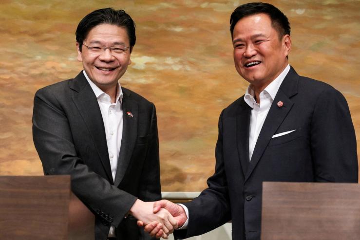 Thailand’s PM Anutin Charnvirakul and Singapore’s PM Lawrence Wong shake hands during a press conference in Bangkok.