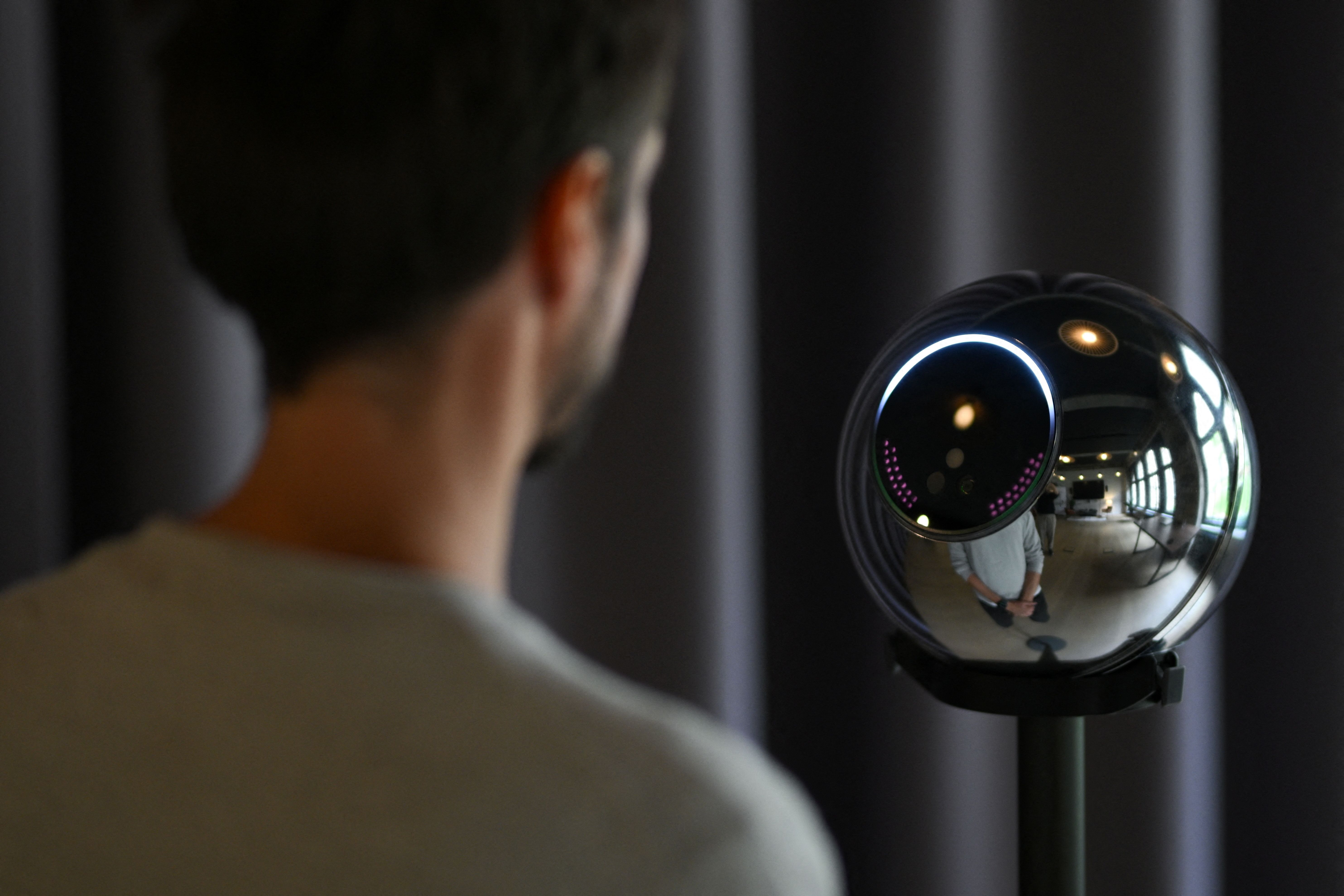 Ricardo Macieira, regional manager, Europe stands to simulate the iris scan near the biometric imaging device, the Orb of the identity and financial public utility Worldcoin, to create a World ID digital passport, being able to trade in cryptocurrency issued, in Berlin, Germany August 1, 2023.