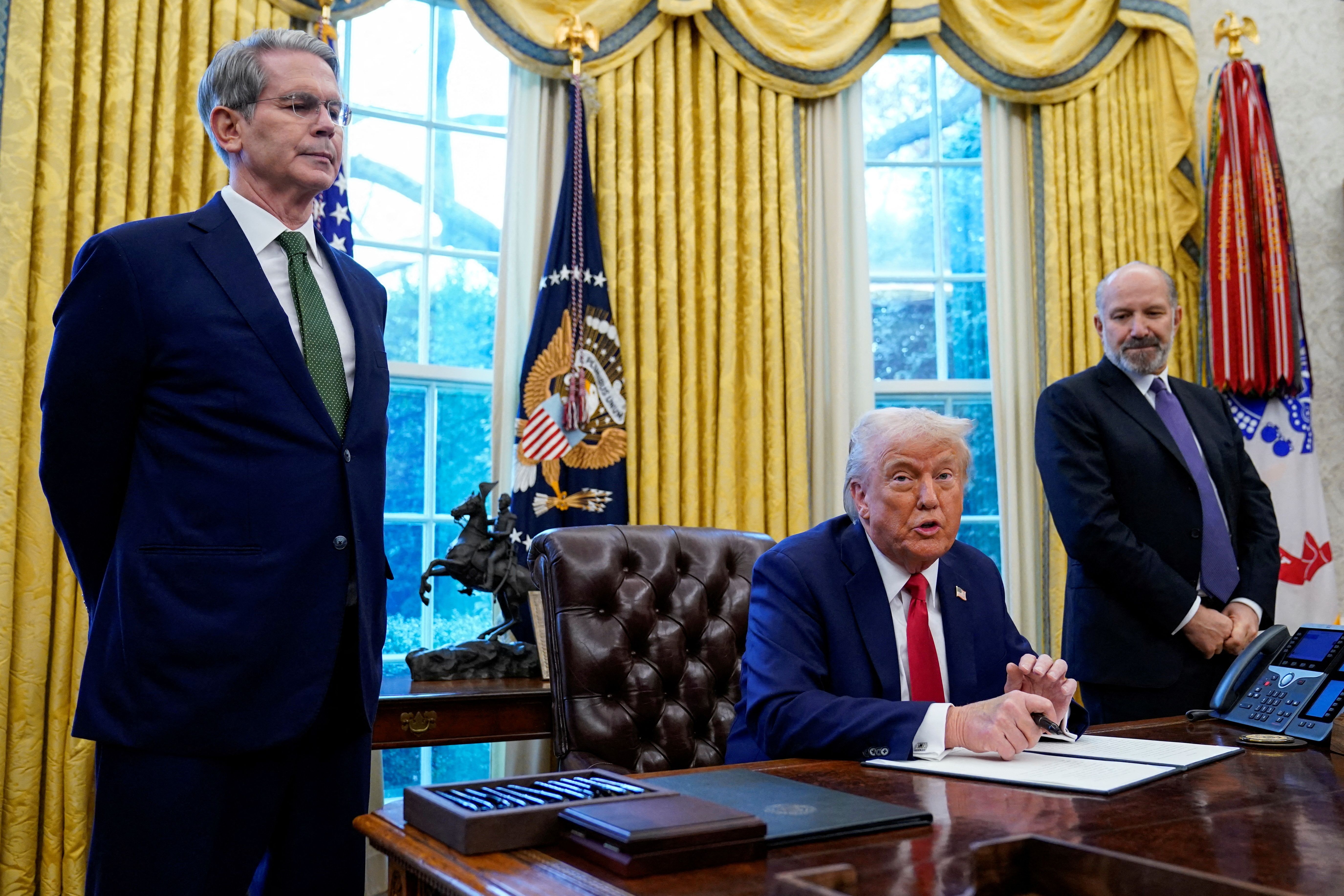 U.S. Secretary of the Treasury Scott Bessent and Howard Lutnick stand as U.S President Donald Trump speaks, at the White House, in Washington, U.S. February 3, 2025.