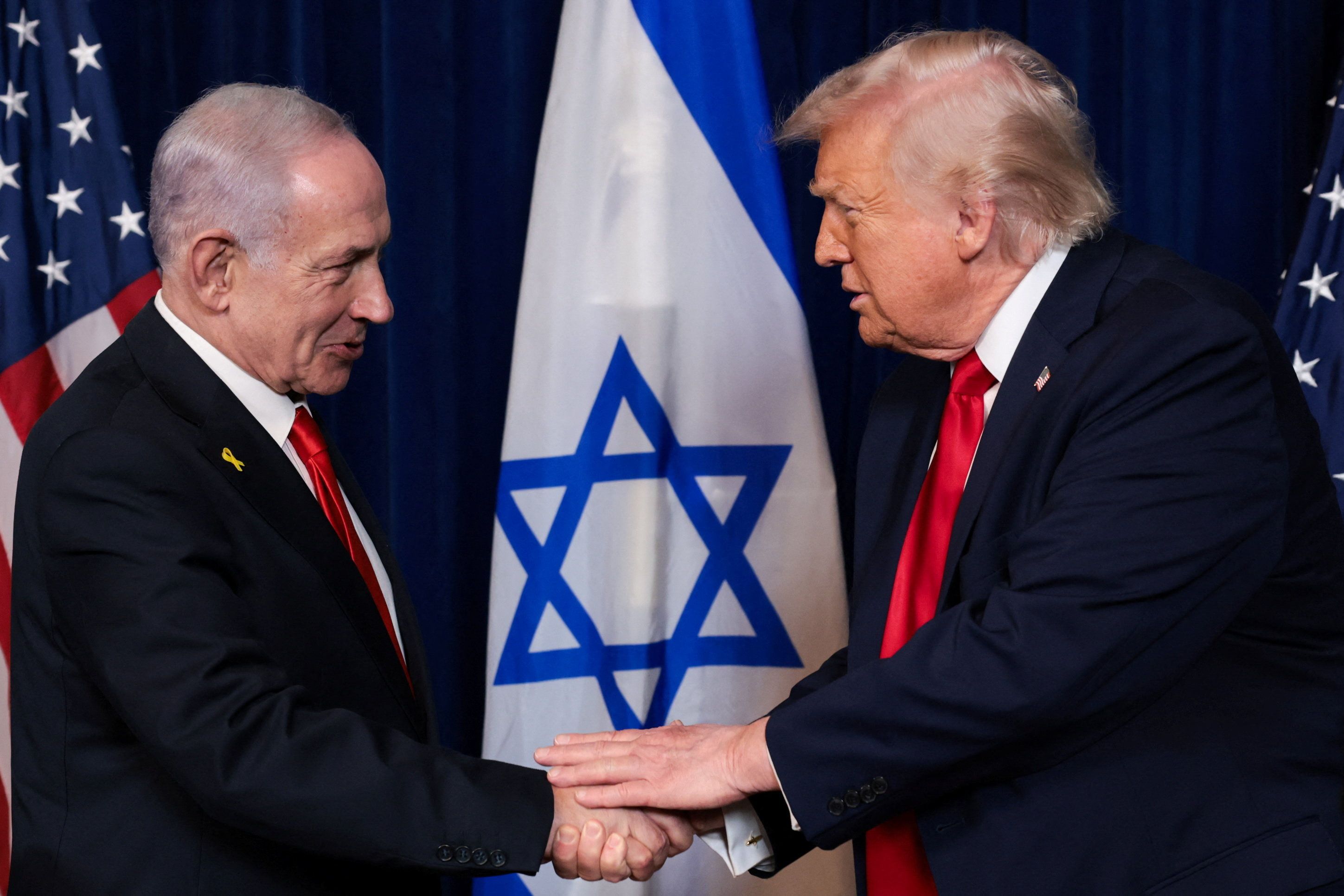 Israeli Prime Minister Benjamin Netanyahu and US President Donald Trump shake hands in Florida