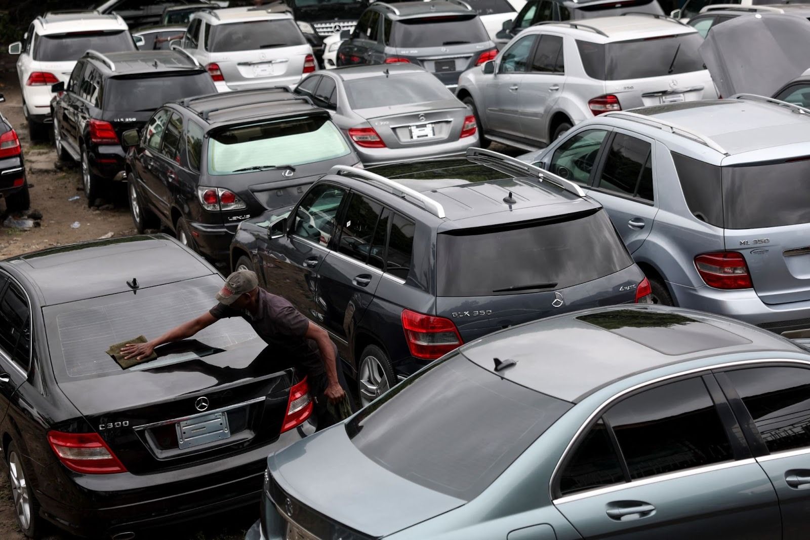 A man cleans a car inside a used-car market in Berger Apapa in Lagos, Nigeria.