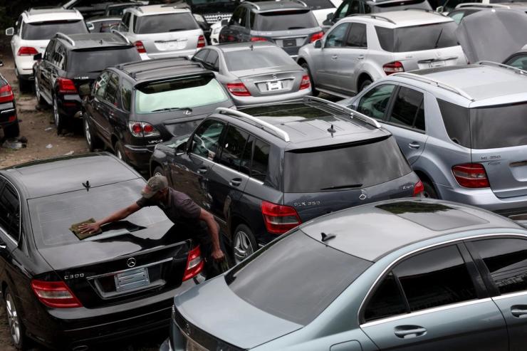 A man cleans a car inside a used-car market in Berger Apapa in Lagos, Nigeria.