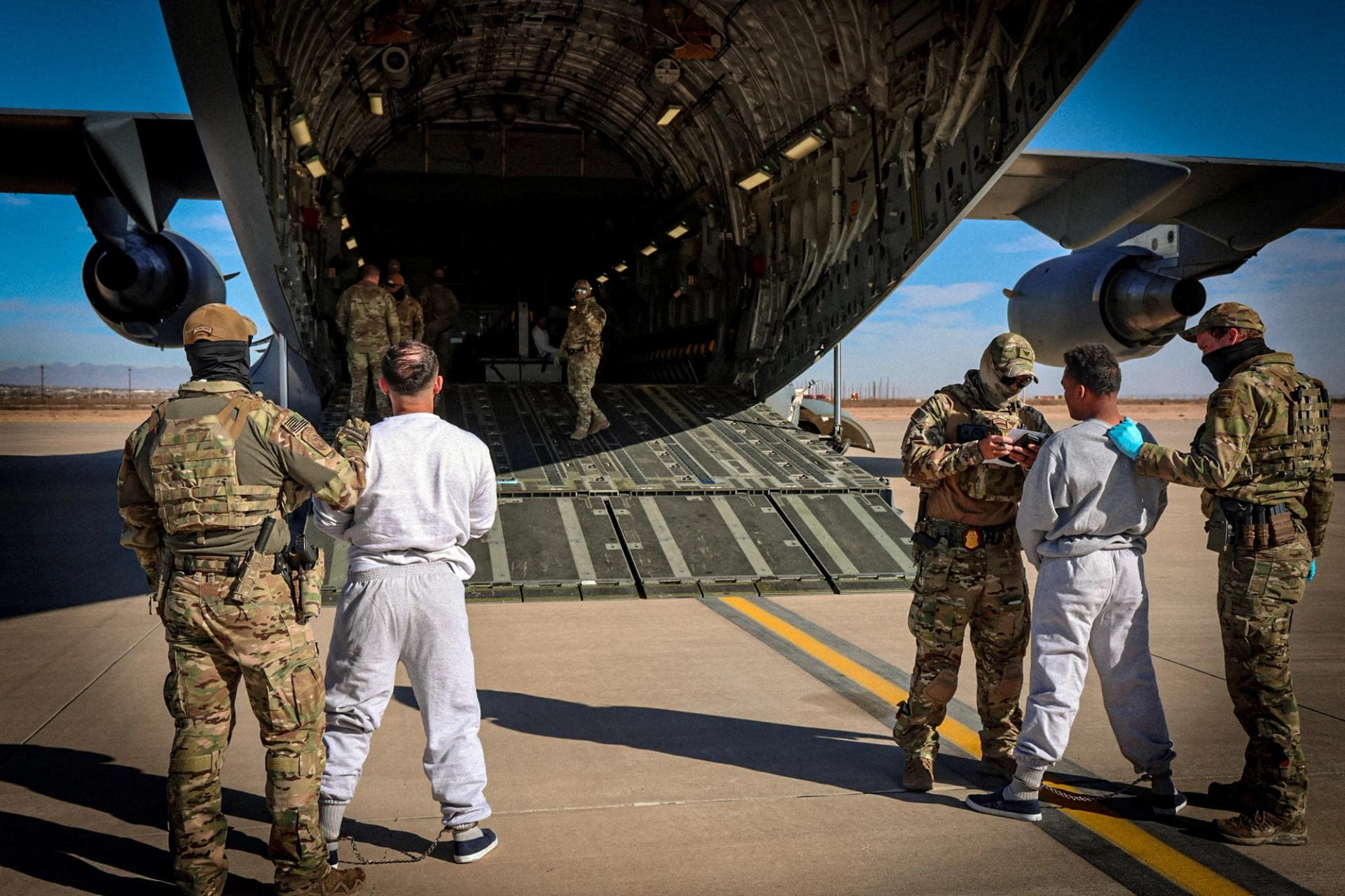 The first U.S. military aircraft to carry detained migrants to a detention facility at Guantanamo Bay is boarded from an unspecified location in the US.