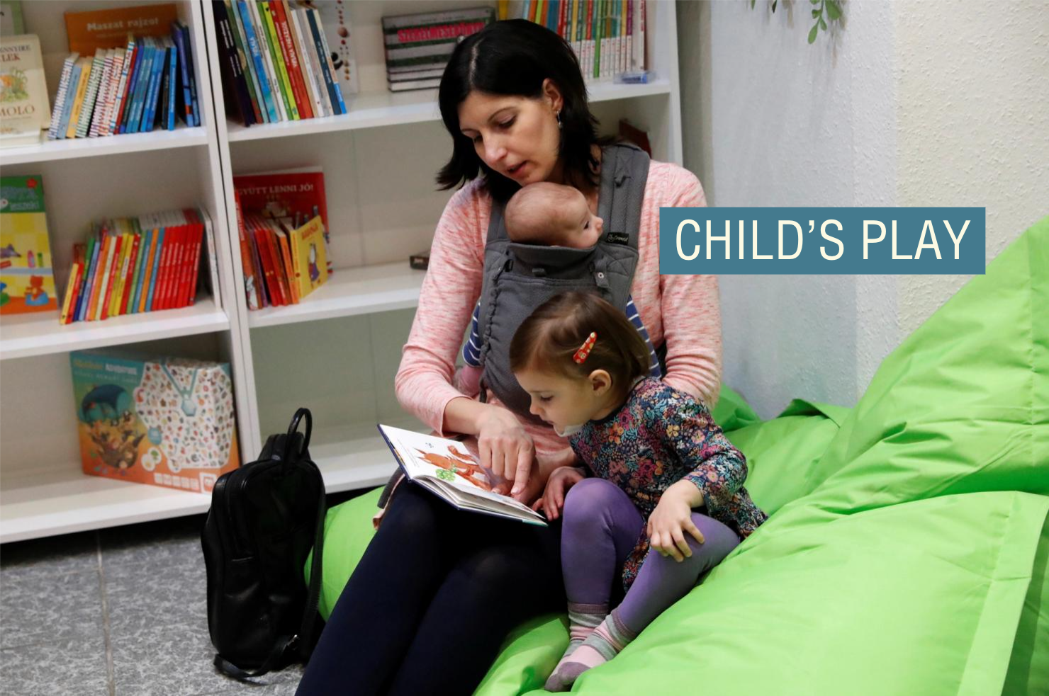 A woman reads a book for her children.