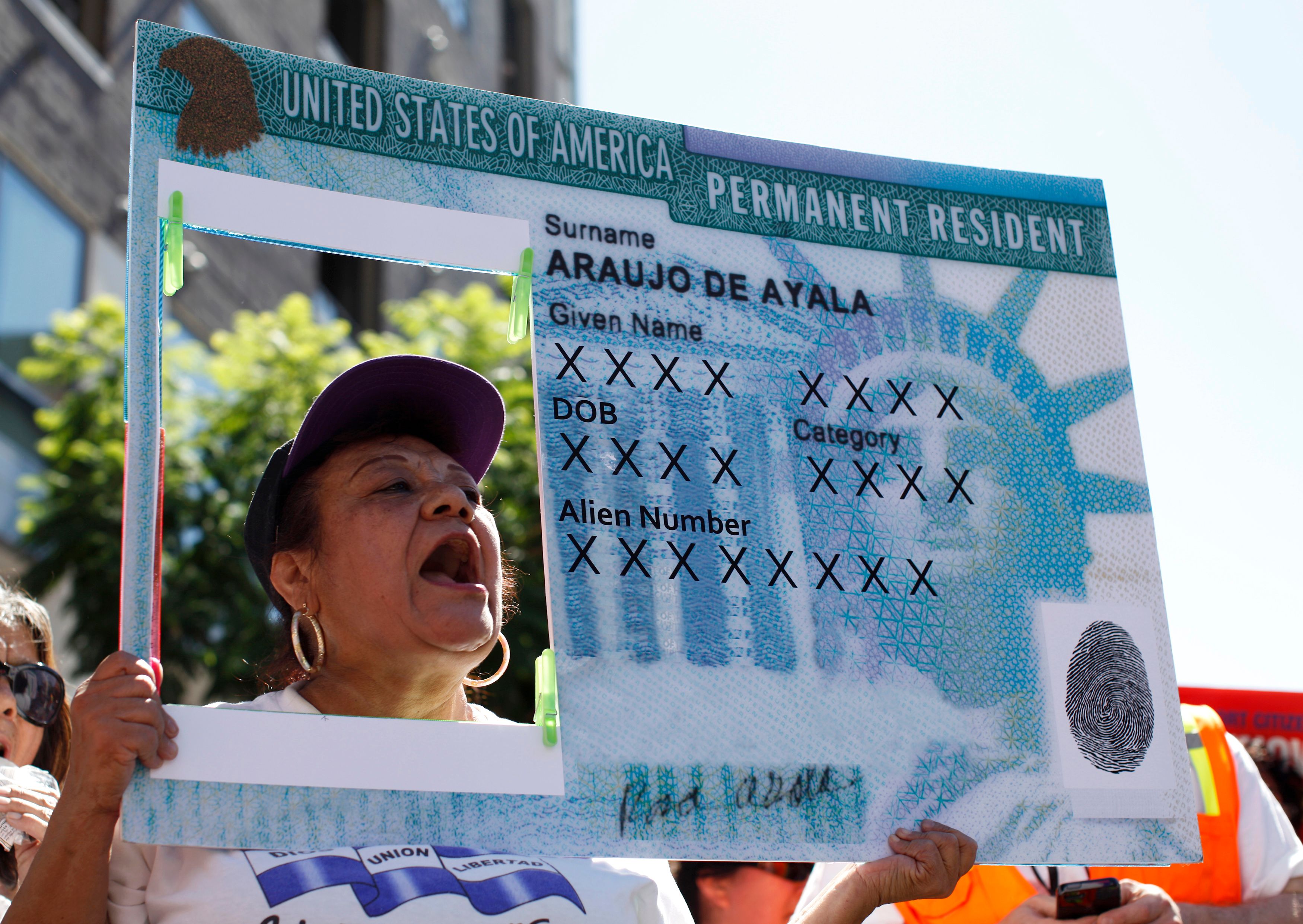 A woman holds a replica green card