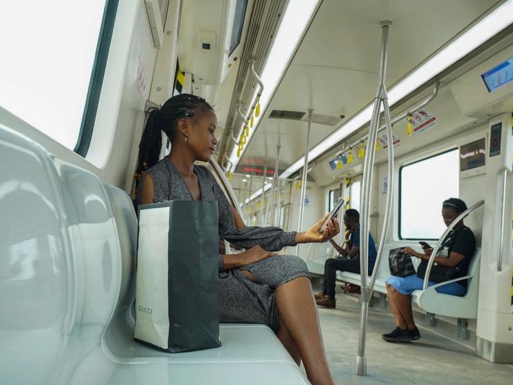 A woman uses her mobile phone as she travels in the Blue Line Rail’s train at Marina Station in Lagos, Nigeria.