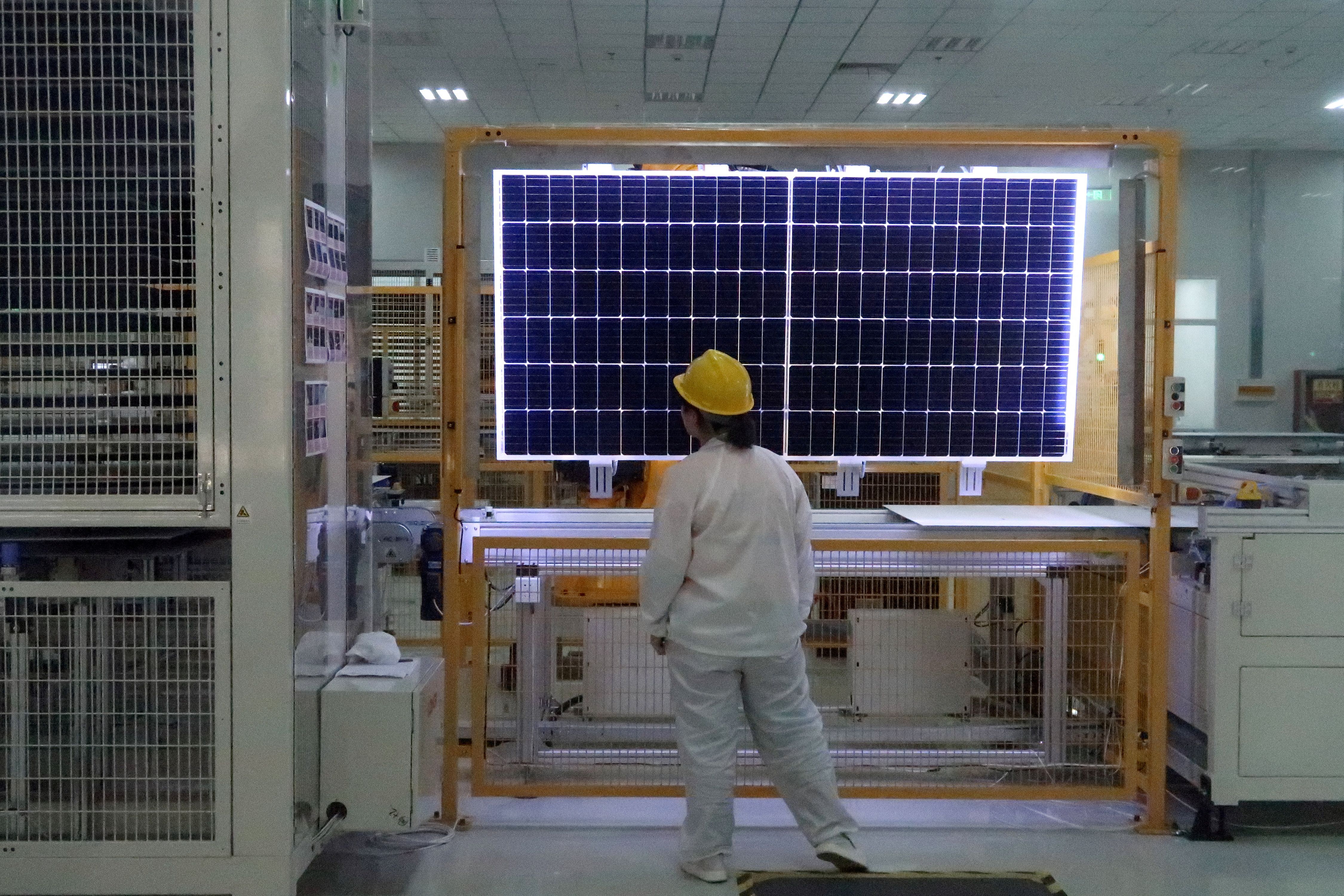 A worker conducts quality-check of a solar module product in China.