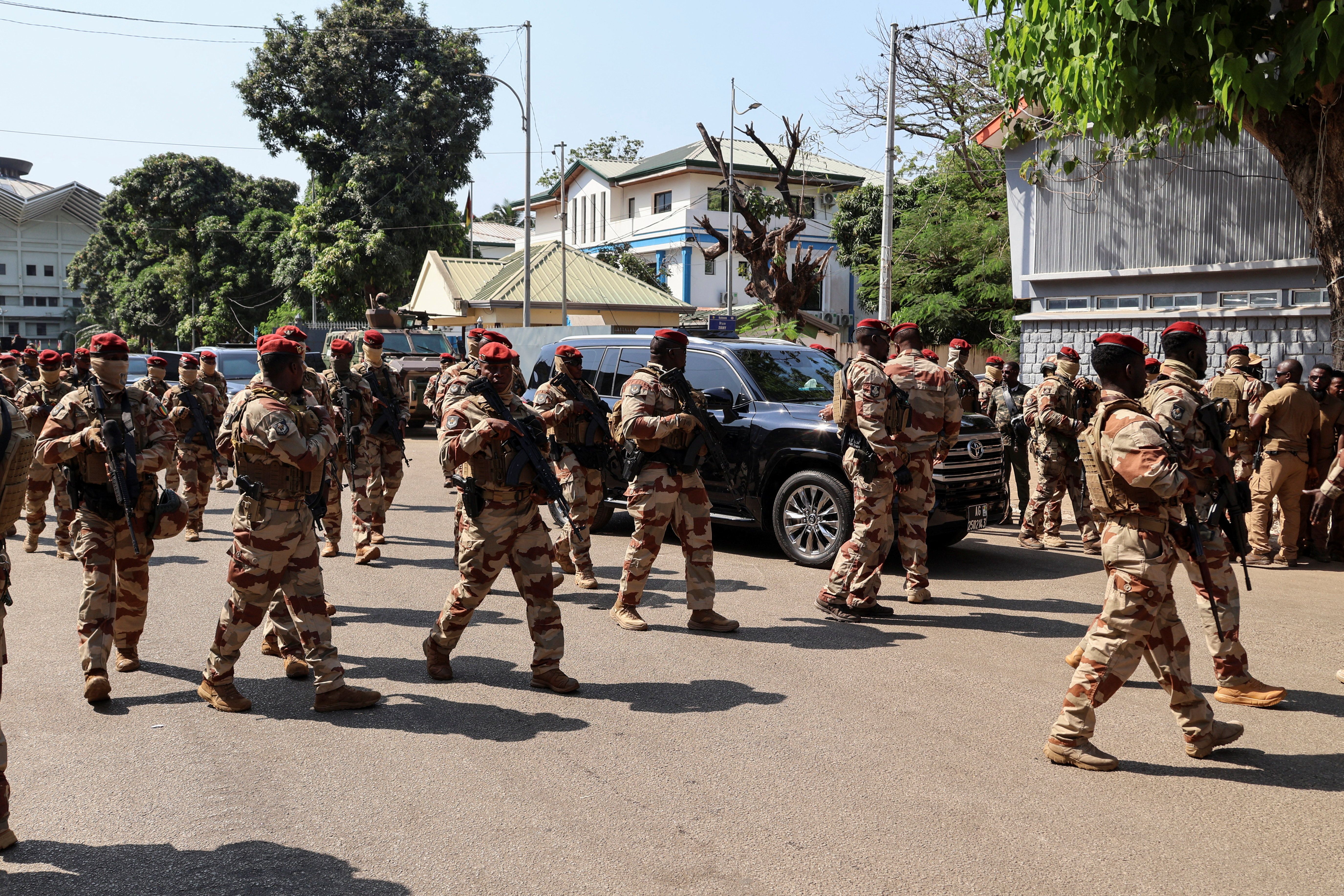 Soldiers surround Guinean leader Mamadi Doumbouya’s car as he arrives to vote during the presidential election at a polling station in Conakry, Guinea, in December