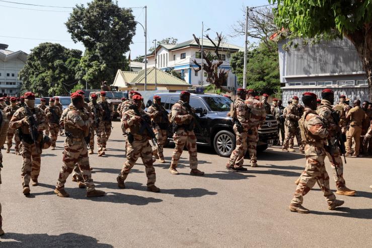 Soldiers surround Guinean leader Mamadi Doumbouya’s car as he arrives to vote during the presidential election at a polling station in Conakry, Guinea, in December