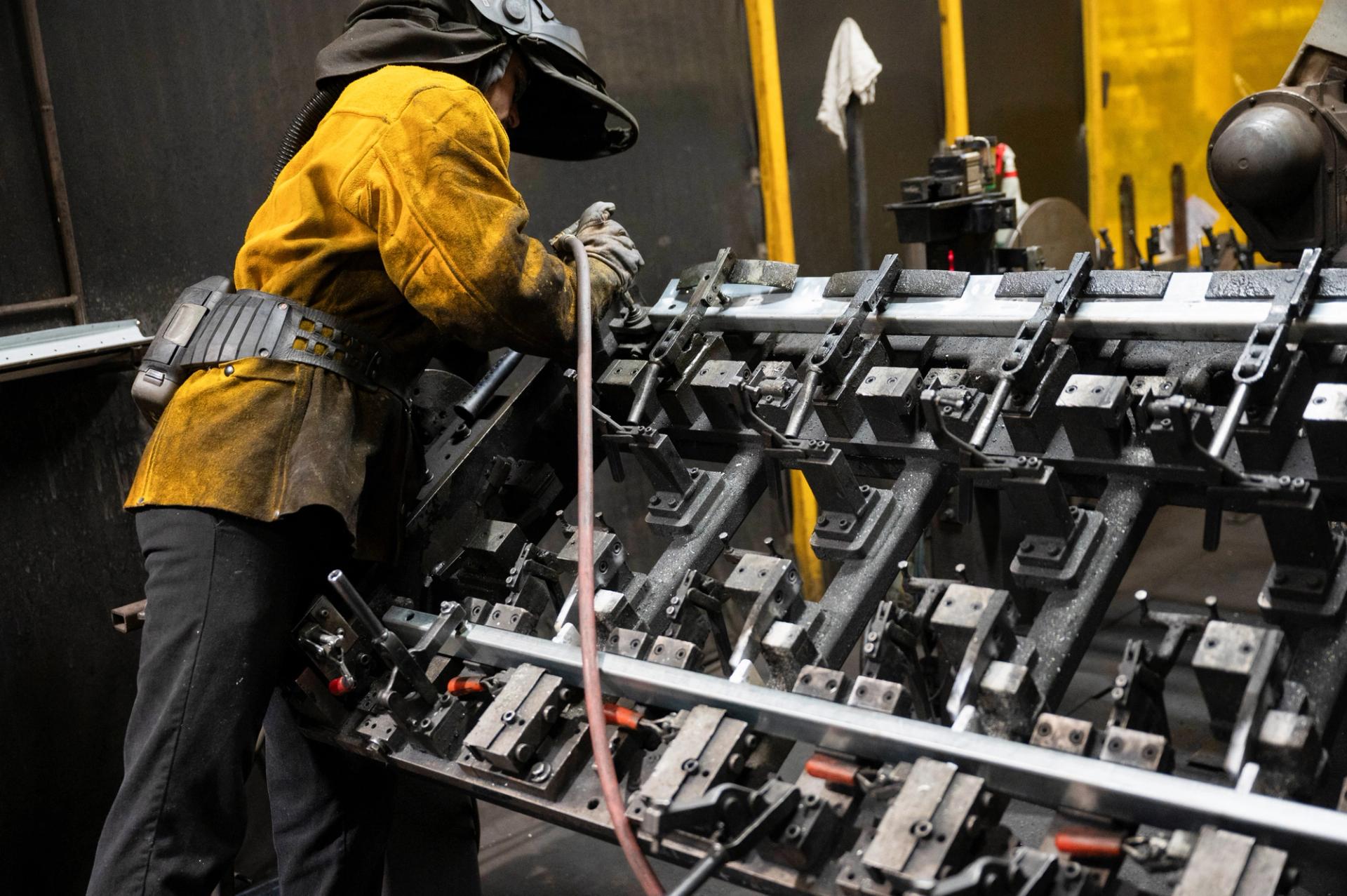 A worker prepares steel to be automatically welded at HCC, a company that uses parts to make combines, at the factory in Mendota, Illinois.