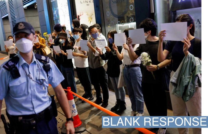 Demonstrators in Hong Kong hold blank sheets of paper to protest coronavirus restrictions.
