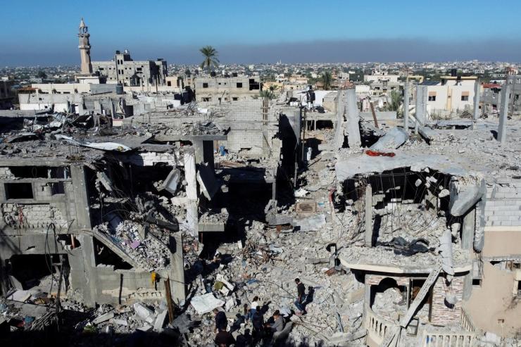 Palestinians walk among the rubble, as they inspect houses destroyed in Israeli strikes during the conflict, amid the temporary truce between Israel and the Palestinian Islamist group Hamas, at Khan Younis refugee camp, in the southern Gaza Strip, November 29, 2023. REUTERS/Mohammed Salem
