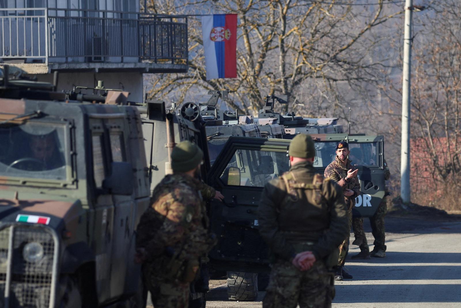 Members of the Italian Armed Forces, part of the NATO peacekeepers mission in Kosovo, stand guard, near a roadblock in Rudare, near the northern part of the ethnically-divided town of Mitrovica, Kosovo, December 27, 2022.
