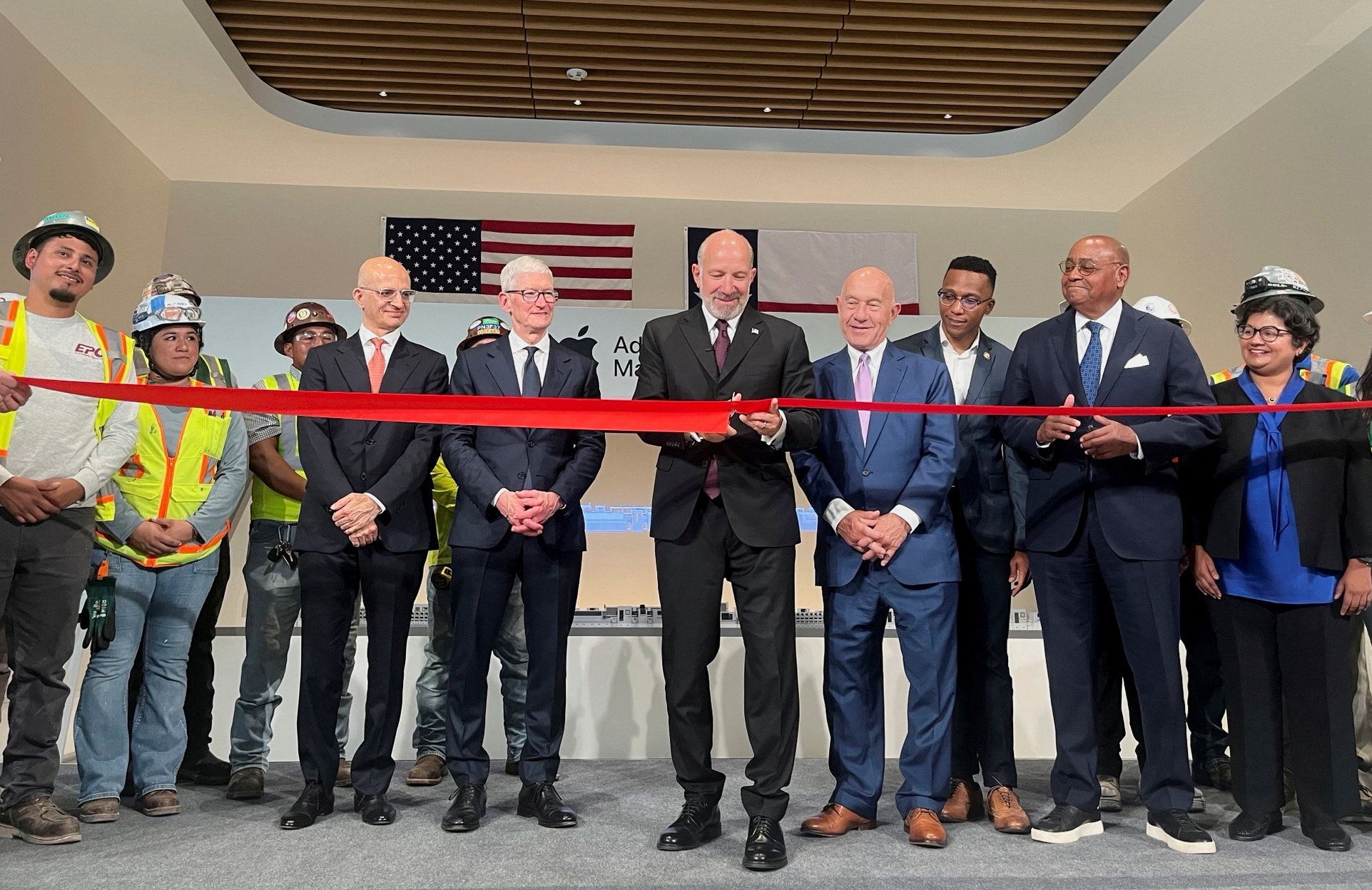 U.S. Secretary of Commerce Howard Lutnick cuts the ribbon alongside Apple’s CEO Tim Cook