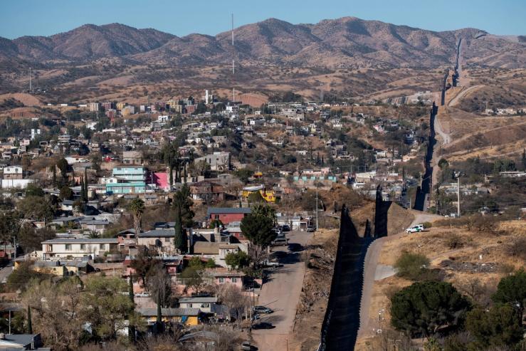 A U.S. Border Patrol vehicle scouts an area near the border wall facing Mexico in Nogales, Arizona, U.S.