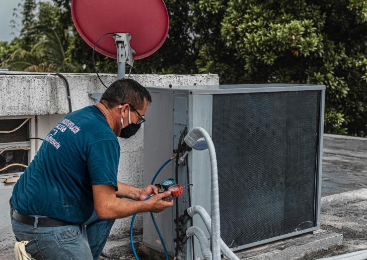A man checks an air conditioner.