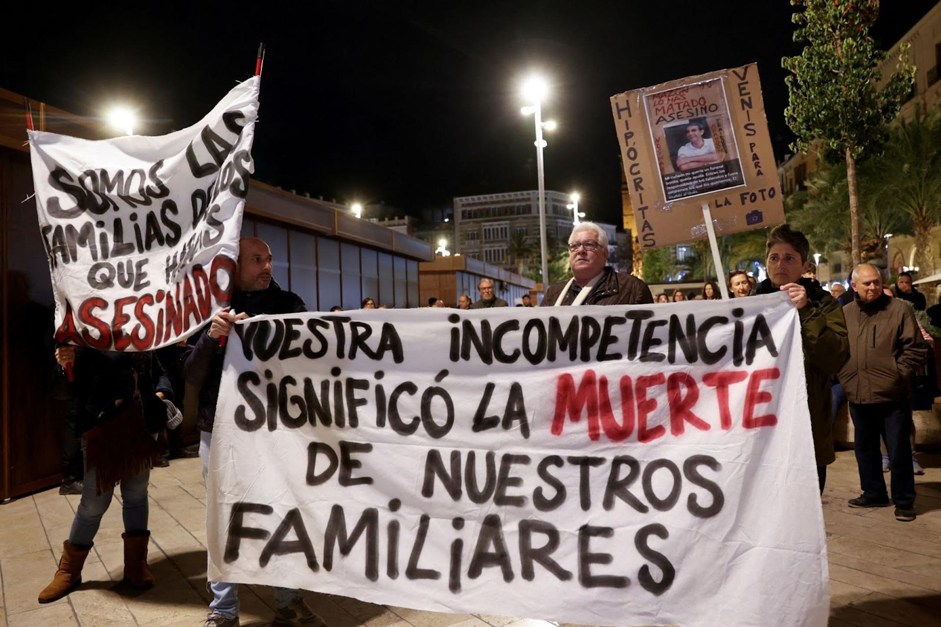 Demonstrators hold a banner that reads “your incompetence meant the deaths of our family members” as members of Spain’s royal family attend a ceremony in memory of victims of Valencia’s floods.