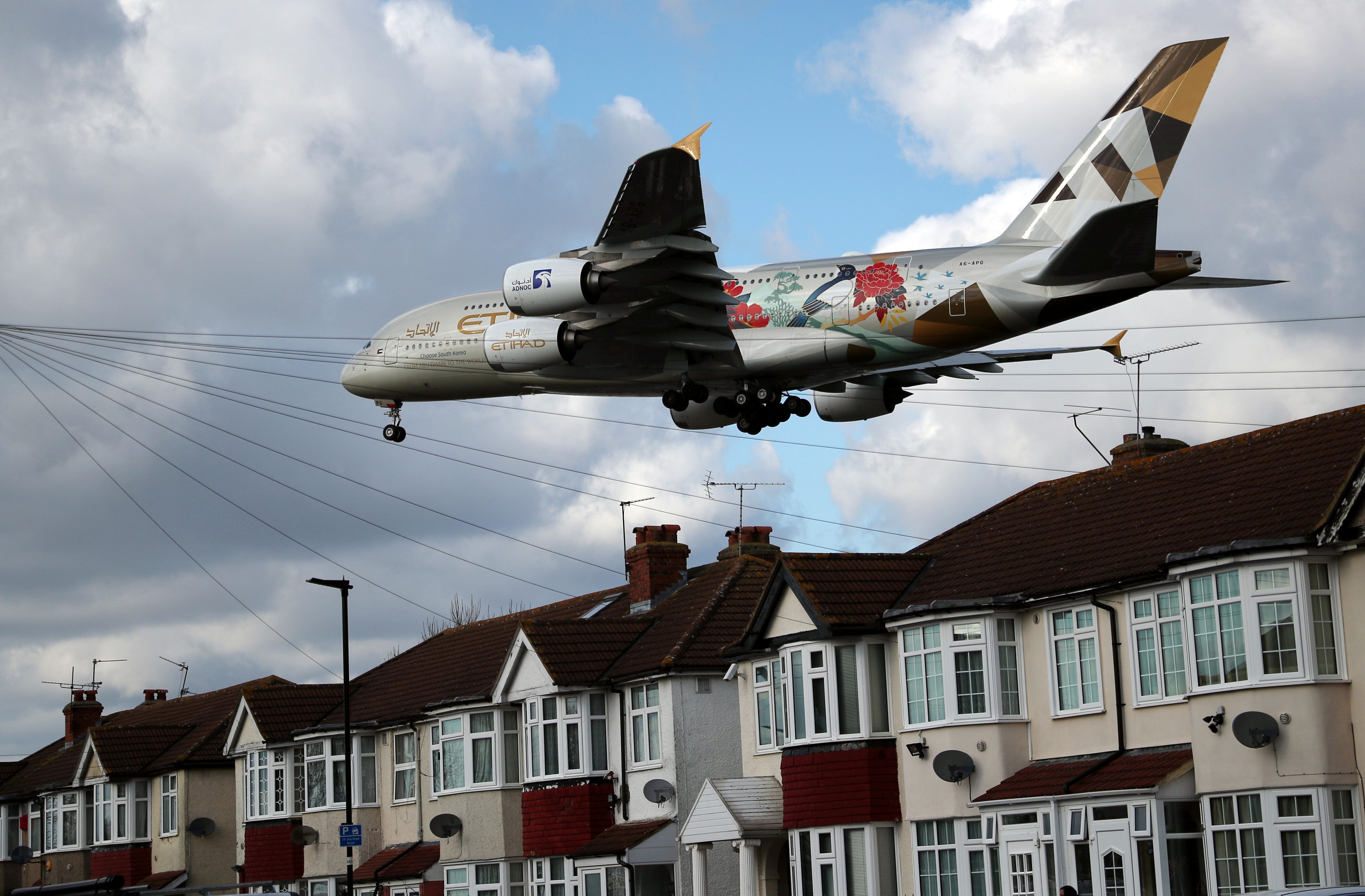 An Etihad Airbus A380 aircraft arrives over the top of residential houses to land at Heathrow Airport in west London.