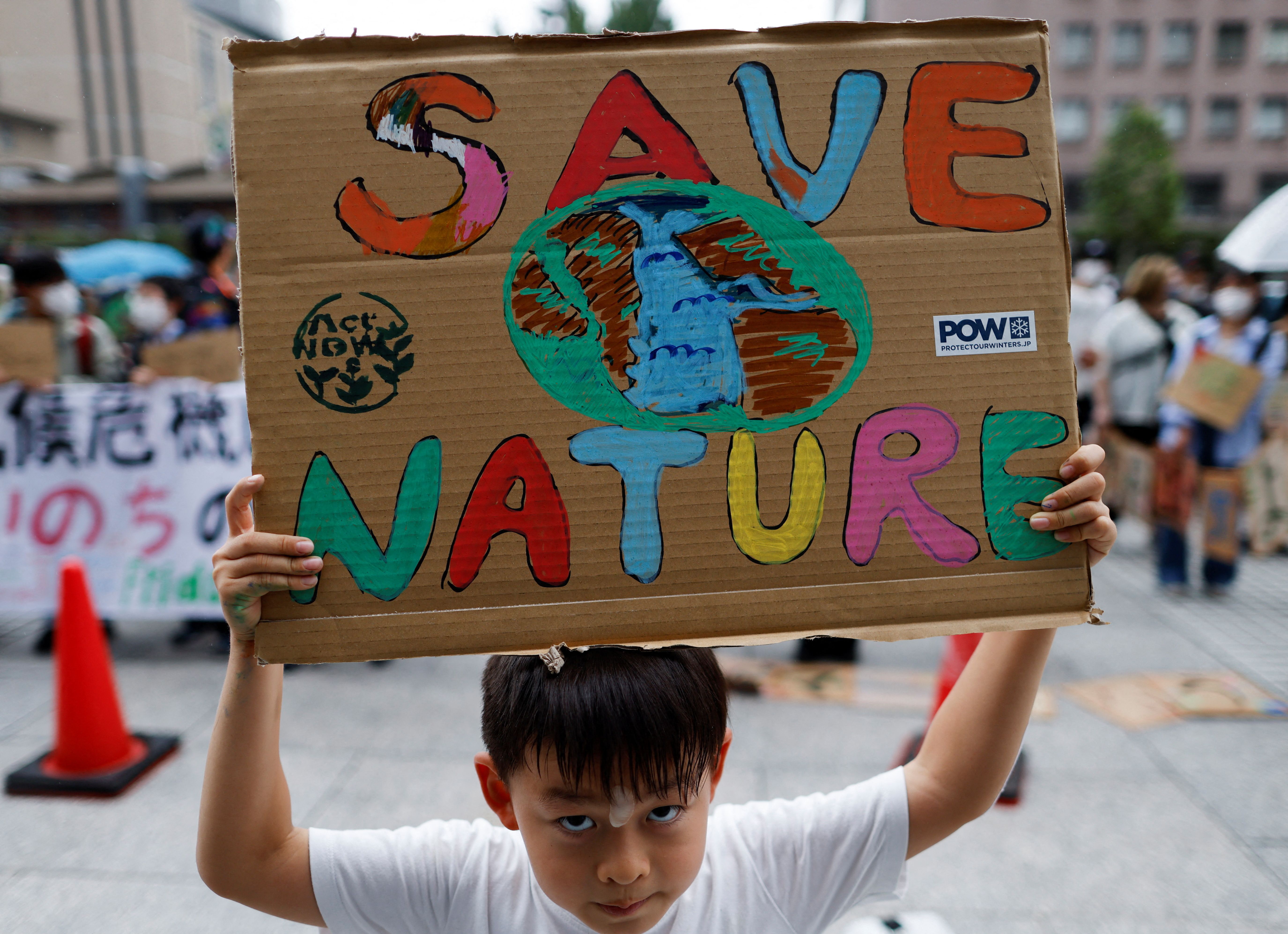 A  child raises a placard as he takes part in a global climate protest