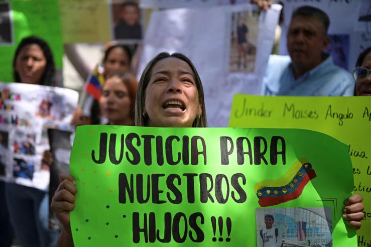 A family member of a Venezuelan who is held in a high-security prison in El Salvador after being deported from the U.S., holds a sign that reads “Justice for our sons”, during a protest to demand their release, in Caracas, Venezuela.