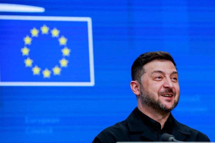 Zelenskyy with an EU flag behind.
