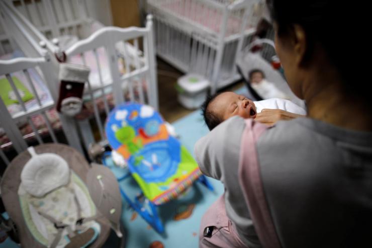 A volunteer takes care of a baby in Seoul.