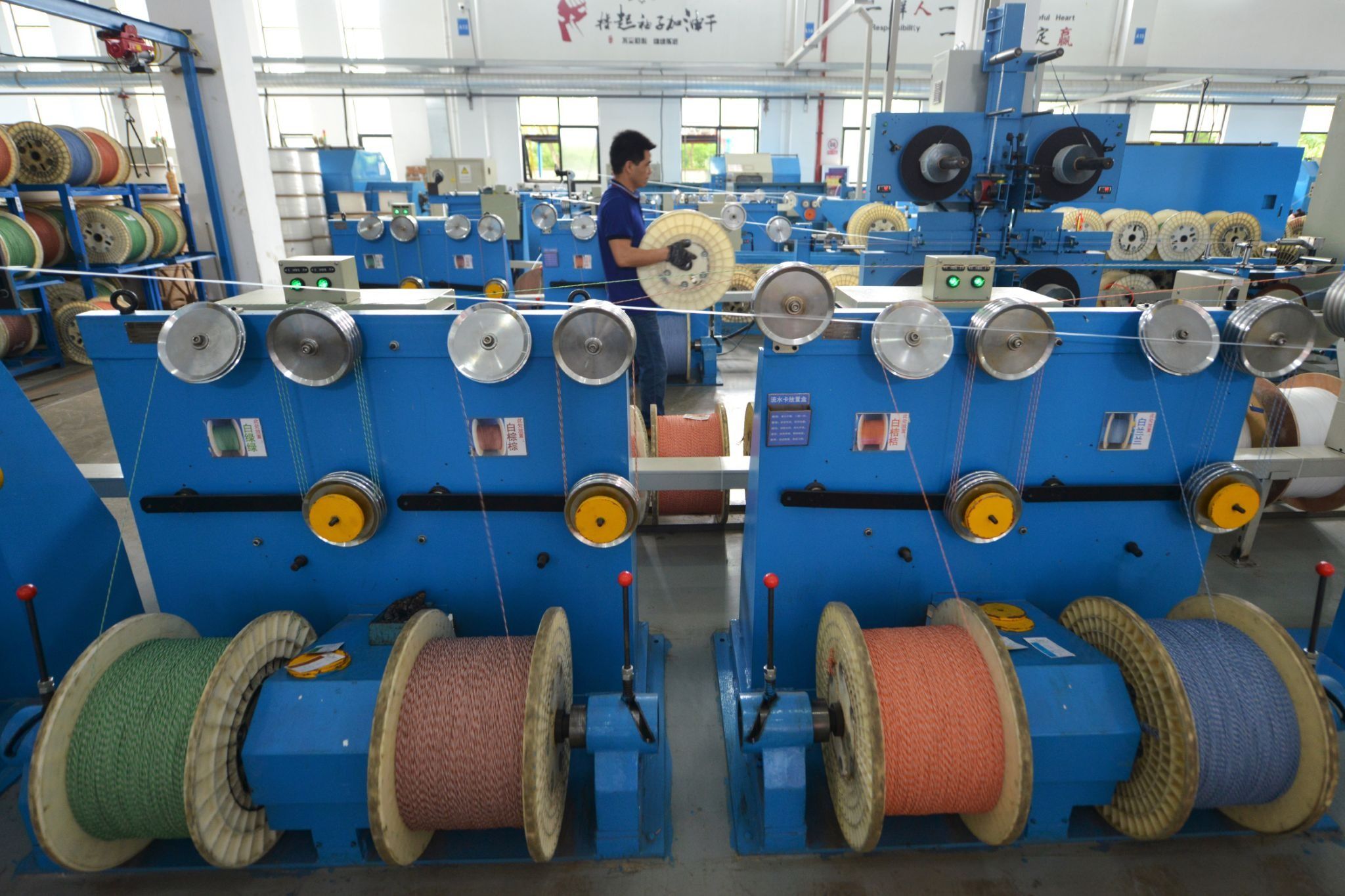 An employee works at a production line manufacturing optical fiber cables in China.