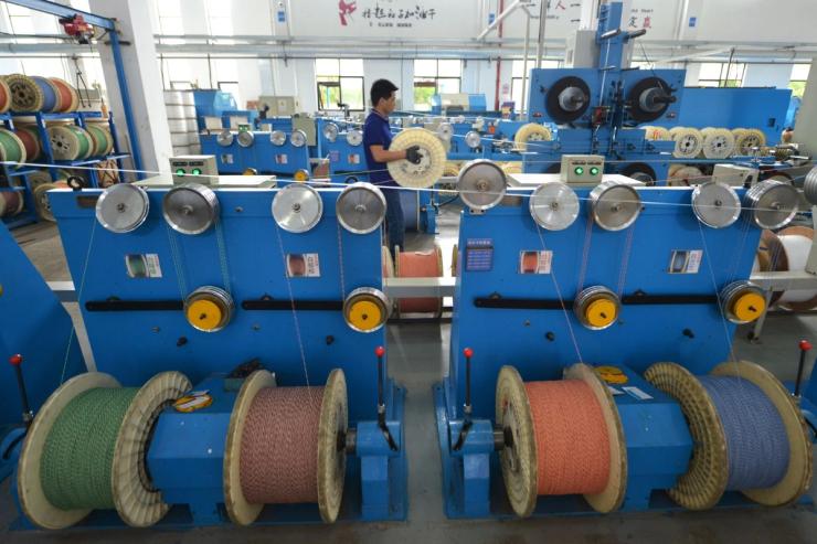 An employee works at a production line manufacturing optical fiber cables in China.