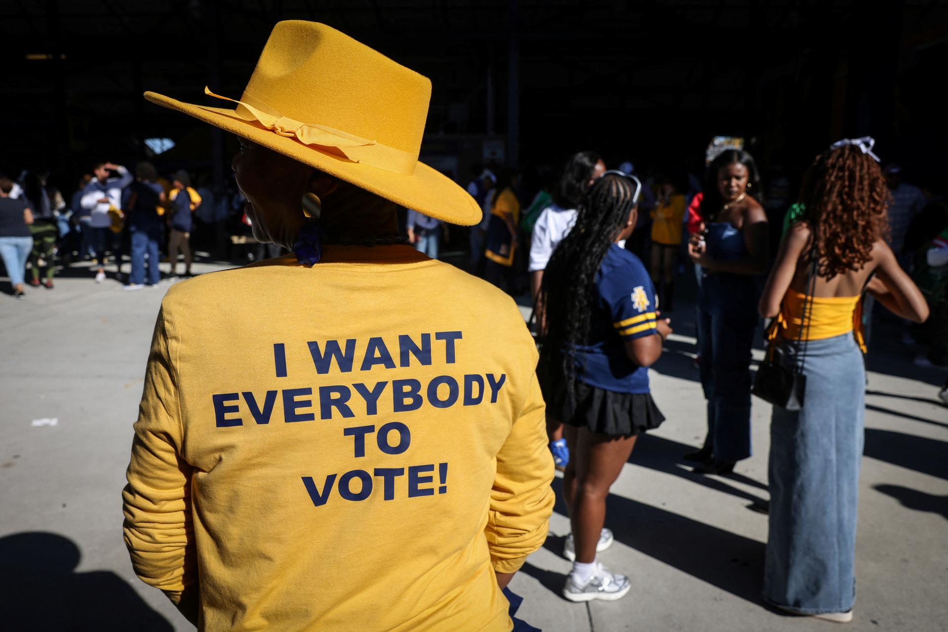 A woman wears a yellow shirt that reads “I want everybody to vote!” ahead of the US election.