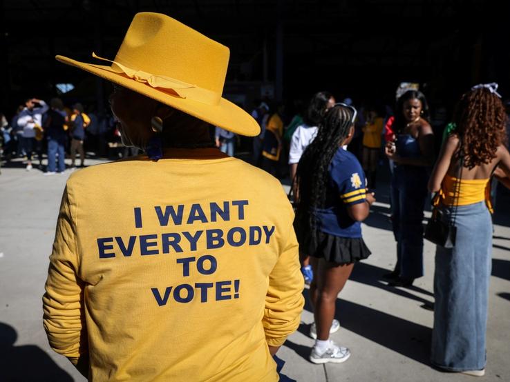 A woman wears a yellow shirt that reads “I want everybody to vote!” ahead of the US election.
