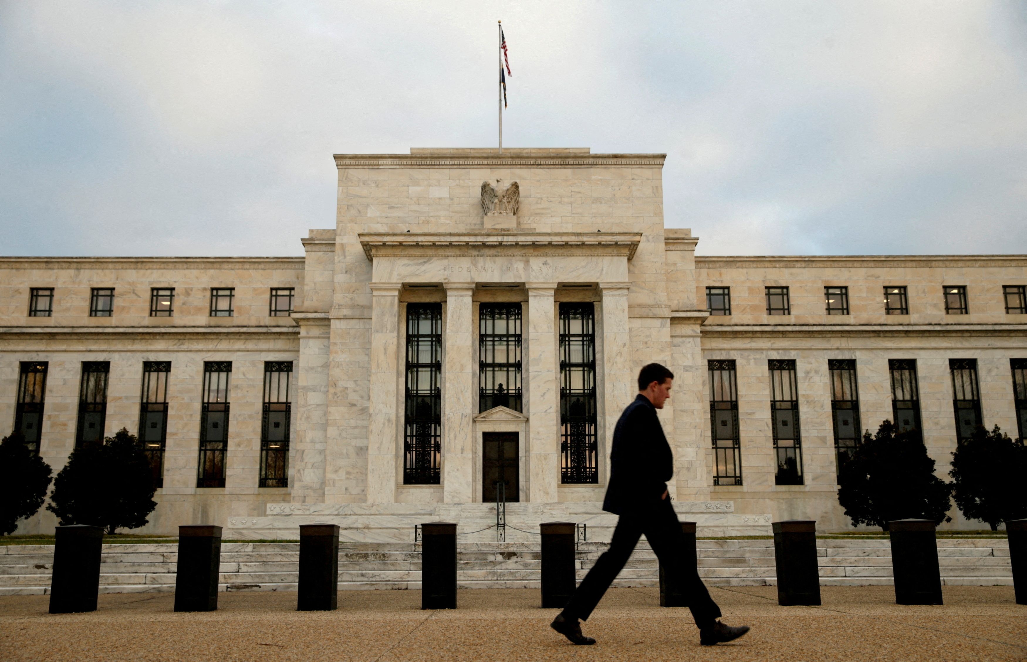A man walks past the Federal Reserve in Washington
