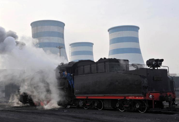 Labourers look out of a steam train transporting coal at a power plant in Shenyang, Liaoning province, China.