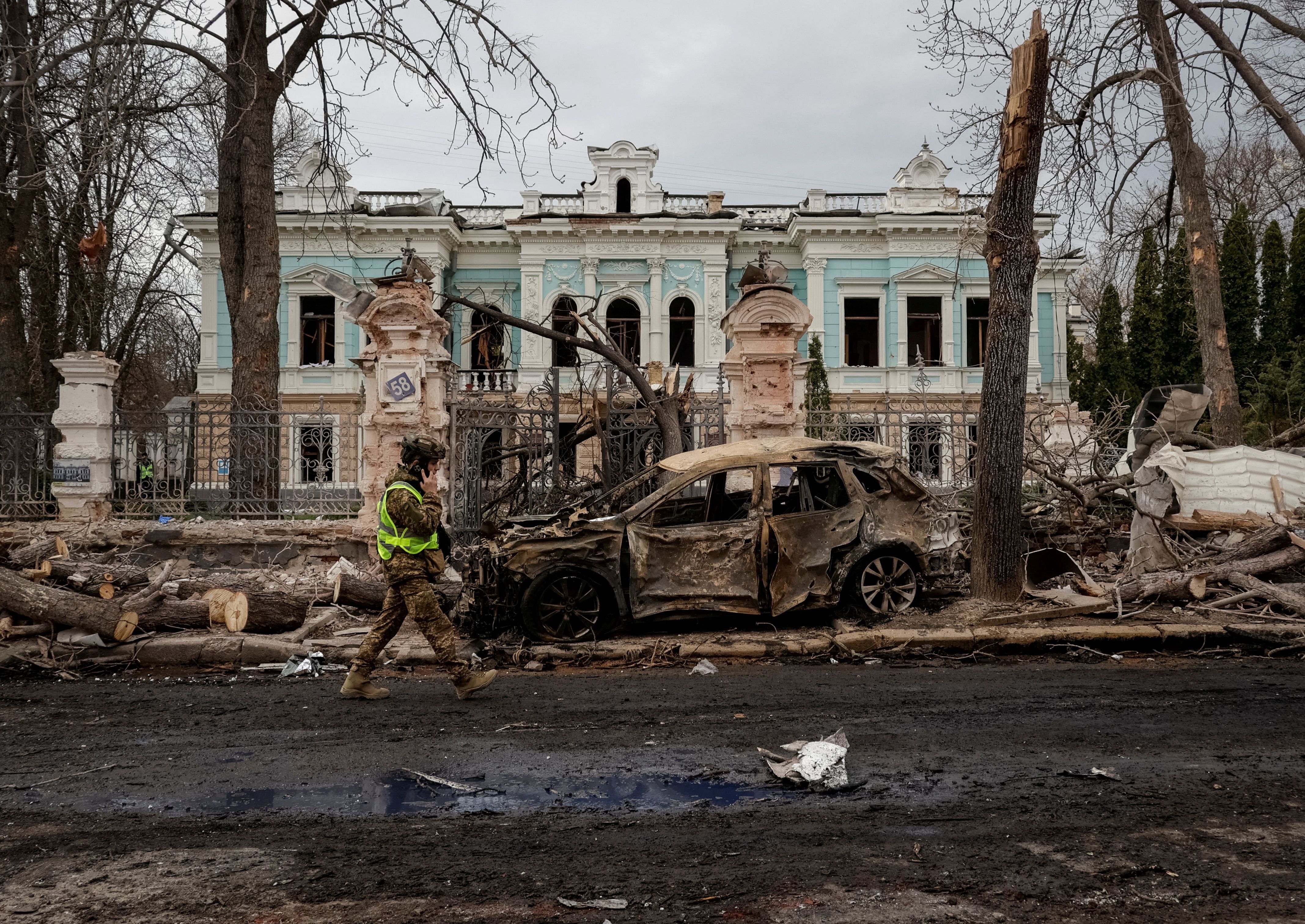A Ukrainian serviceman walks at the site of a Russian missile strike.