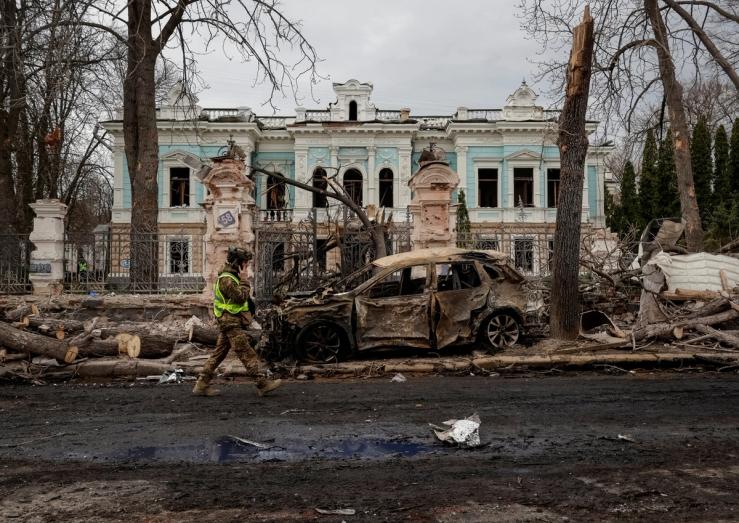 A Ukrainian serviceman walks at the site of a Russian missile strike.