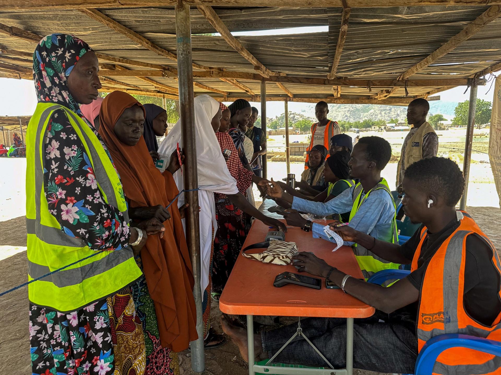 Women being registered to receive food aid, following flooding and rising inflation last month.