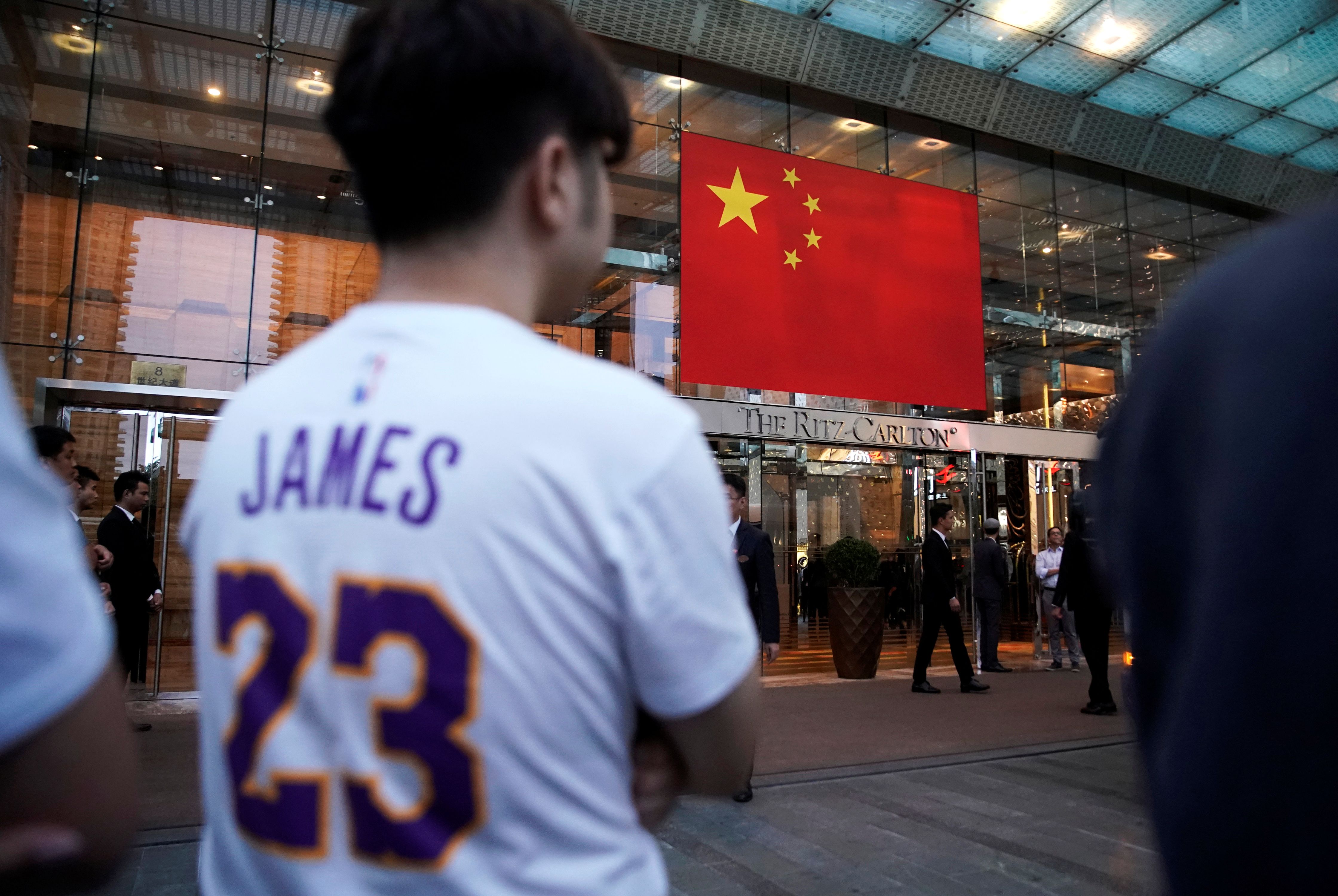 A man wearing a T-shirt with name and number of LeBron James of NBA Los Angeles Lakers stands outside a Ritz-Carlton hotel in Shanghai