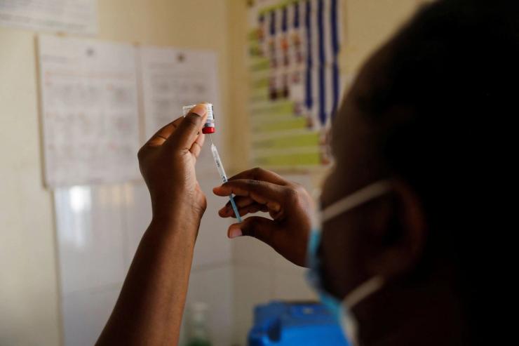A nurse fills a syringe with malaria vaccine.