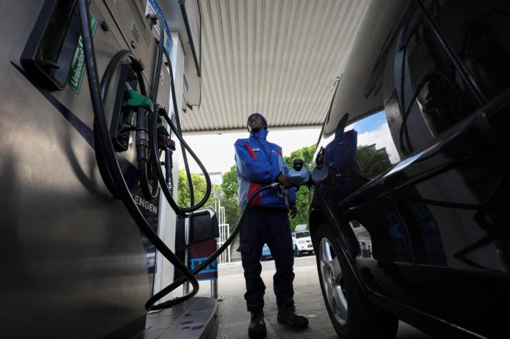 A worker fills a car at a fuel station in Cape Town, South Africa.
