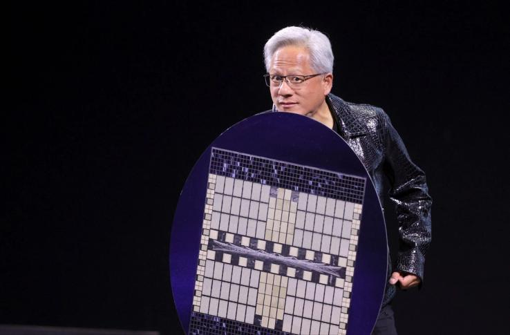 Nvidia CEO Jensen Huang holds a shield designed to look like a computer chip.