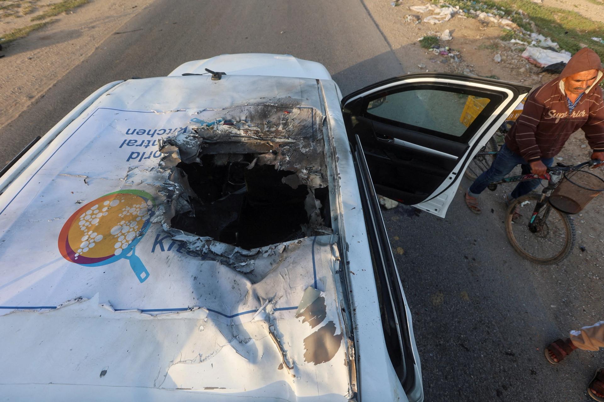 A Palestinian man rides a bicycle past a damaged vehicle where employees from the World Central Kitchen (WCK), including foreigners, were killed in an Israeli airstrike, according to the NGO as the Israeli military said it was conducting a thorough review at the highest levels to understand the circumstances of this "tragic" incident, amid the ongoing conflict between Israel and Hamas, in Deir Al-Balah, in the central Gaza, Strip April 2, 2024. REUTERS/Ahmed Zakot TPX IMAGES OF THE DAY