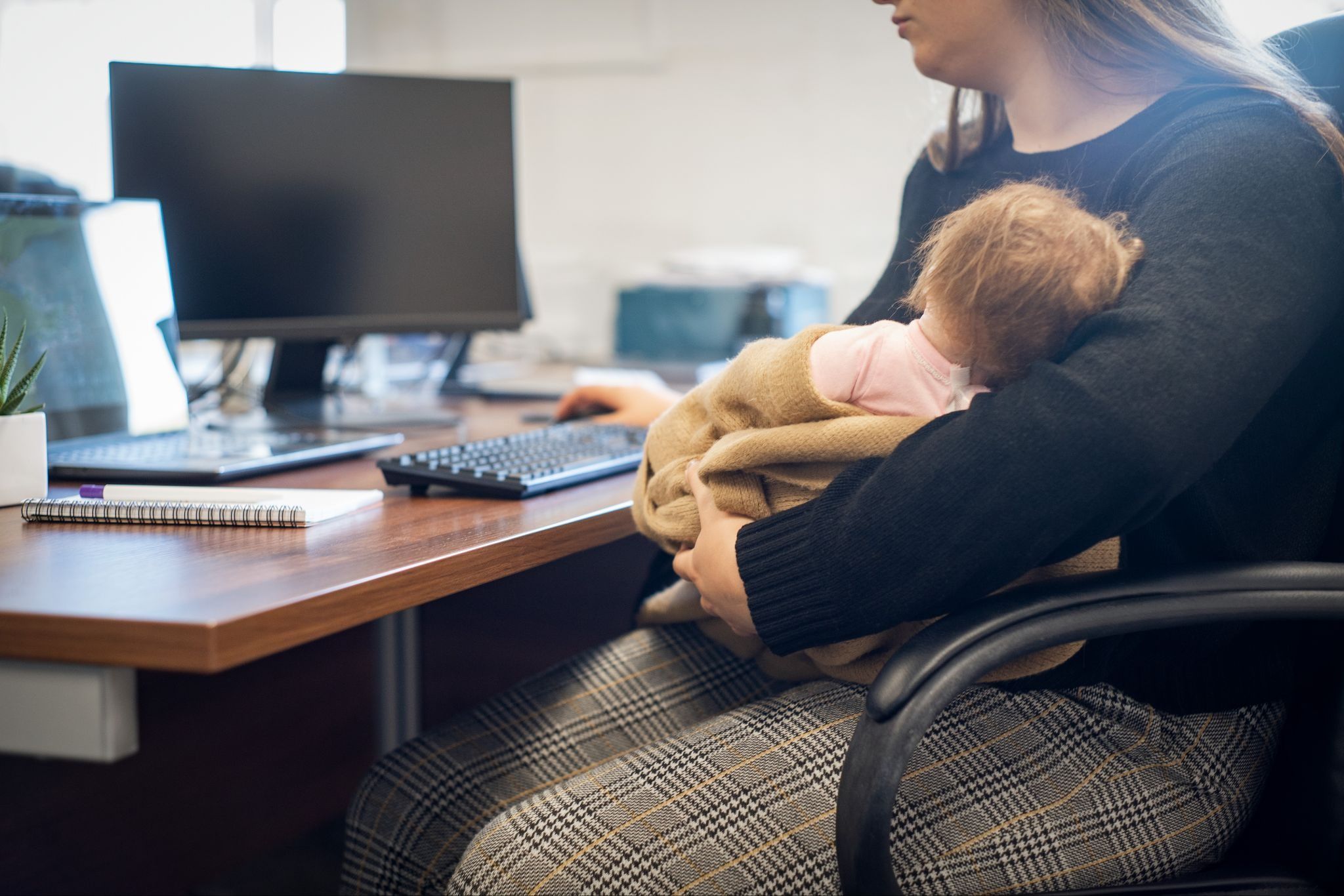 A mother with her baby, working remotely 