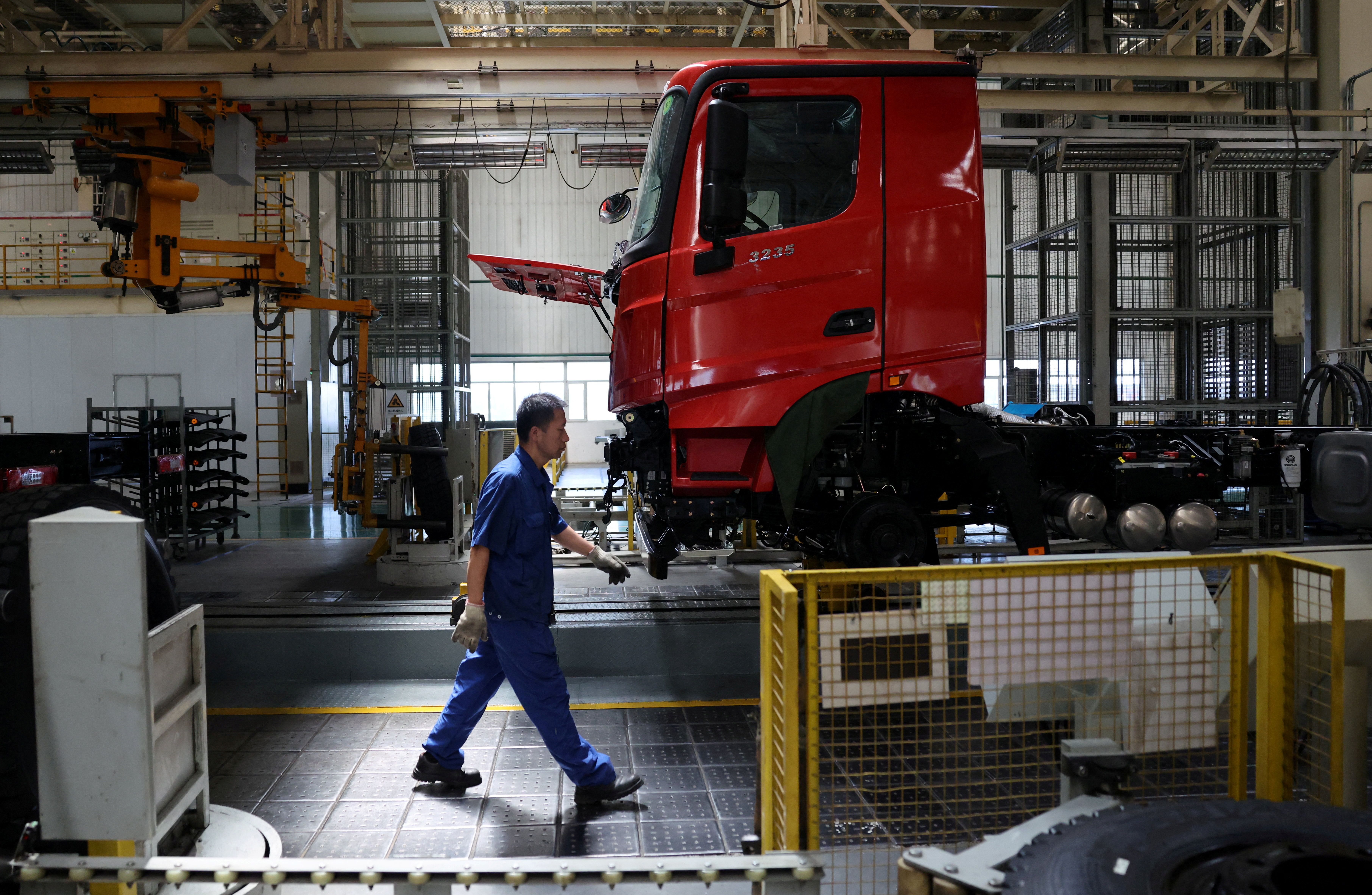 An employee walks at the truck assembly line at Beiben Trucks Group factory. 